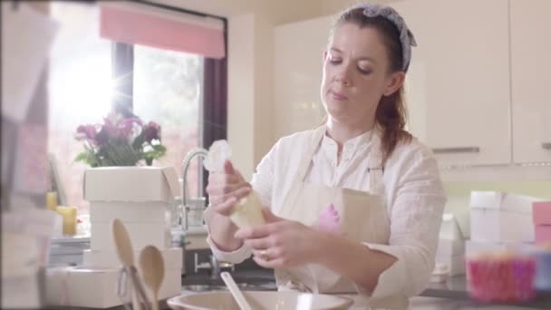 Vrouw leidingen crème op cupcakes — Stockvideo