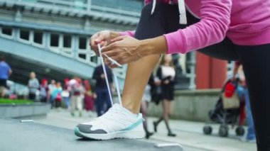 Sportif kadın onun ayakkabı bağı bağlar
