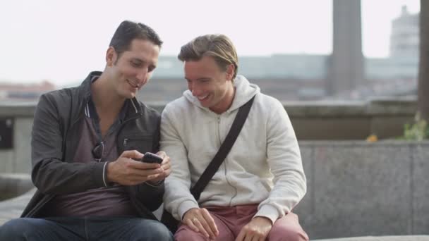 Друзья мужчины тусуются с мобильным телефоном — стоковое видео