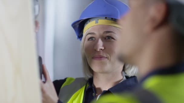 Tradesman  showing apprentice how to use a drill — Stock Video