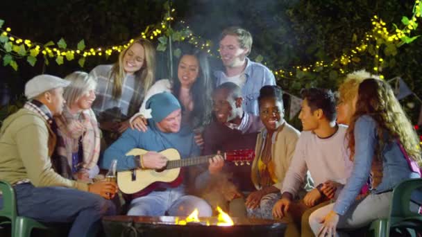 Amigos socializar y tocar la guitarra — Vídeos de Stock