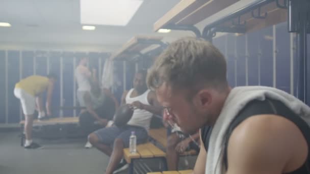 Hombre en gimnasio vestuario rehidratante con agua — Vídeo de stock