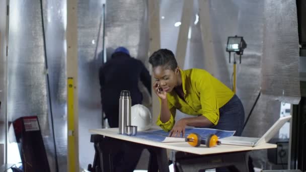 Женщина-архитектор разговаривает по телефону — стоковое видео