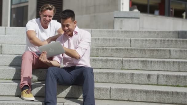Друзья мужчины тусуются с планшетом — стоковое видео
