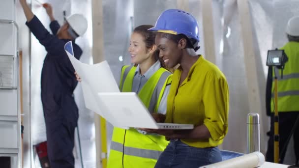 Ingenieros que miran los planos en el sitio de construcción — Vídeos de Stock