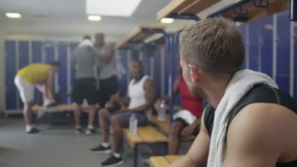 Homme sérieux assis dans le vestiaire de la salle de gym — Video