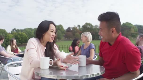 Pareja charlando en la cafetería al aire libre — Vídeos de Stock