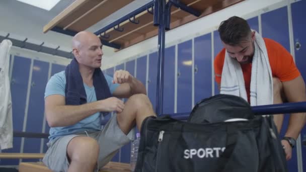 Спортивні гравці спілкуються в роздягальні — стокове відео