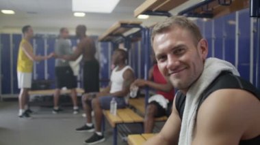 spor salonu soyunma odasında oturan gülümseyen adam