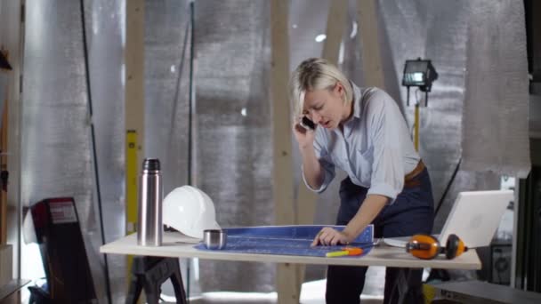 Женщина-архитектор разговаривает по телефону — стоковое видео