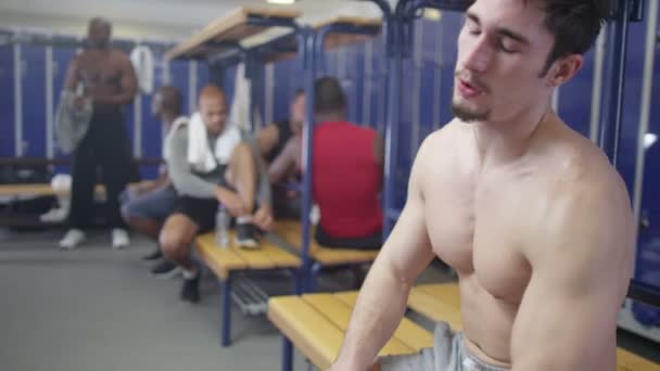Wyczerpany mężczyzna siedzący w szatni siłowni — Wideo stockowe