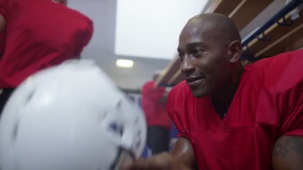 Football player in team locker room — Stock Video