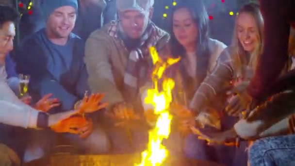 Friends warming hands in front of fire — Stock Video