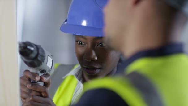 Handwerker zeigt Lehrling, wie man eine Bohrmaschine bedient — Stockvideo