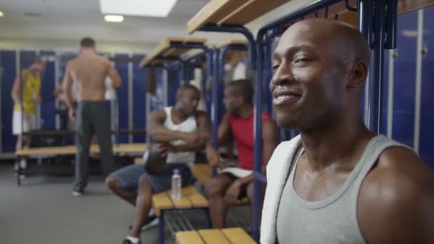 Spor salonu soyunma odasında oturan gülümseyen adam — Stok video