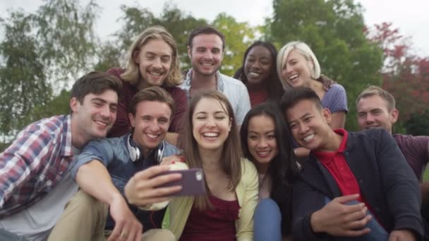 Amigos posan para la foto con el teléfono móvil — Vídeo de stock