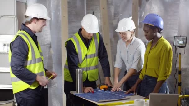 Ingenieure betrachten Baupläne — Stockvideo