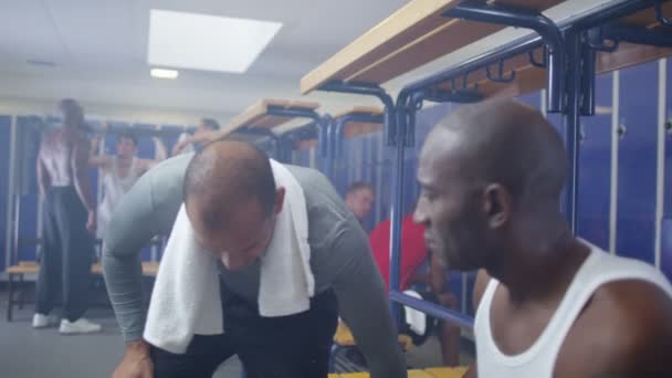Sports players chatting in locker room — Stock Video
