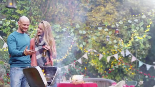 Pareja charlando por la barbacoa — Vídeo de stock