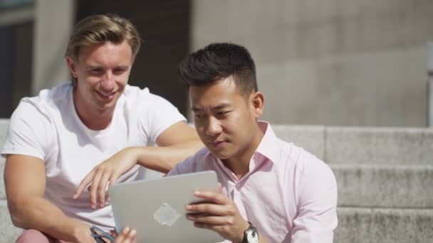 Männliche Freunde hängen mit einem Computer-Tablet herum — Stockvideo