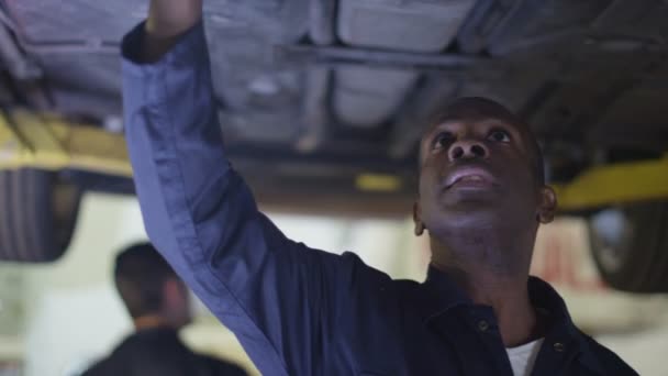 mécanicien travaillant sous une voiture  