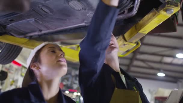 Mechaników pracujących pod spodem samochodu — Wideo stockowe