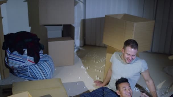 Homosexuální pár sedí mezi boxy v domě — Stock video