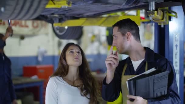 Механик говорит с клиентом о машине — стоковое видео