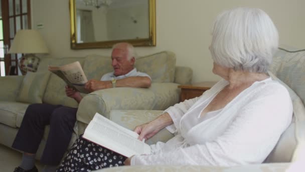 Ανώτερος ζευγάρι ανάγνωση στο σπίτι — Αρχείο Βίντεο