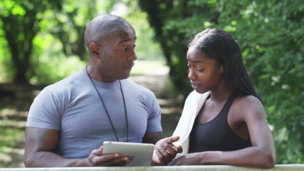 Femme avec formateur parlant dans le parc — Video