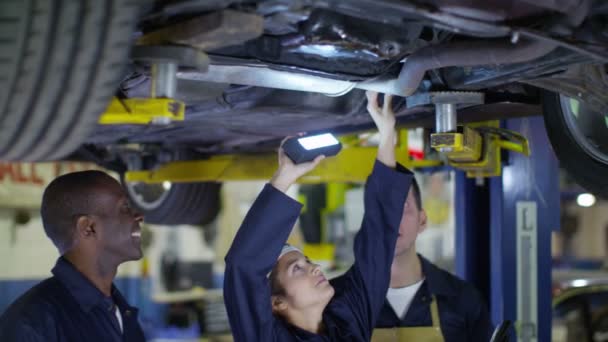 Mecánicos trabajando debajo de un coche — Vídeos de Stock