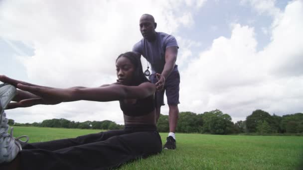 Woman stretching out with trainer — Stock Video