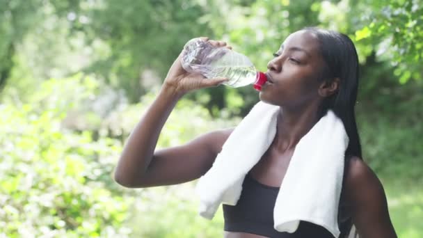 Женщина пьет бутылку воды — стоковое видео