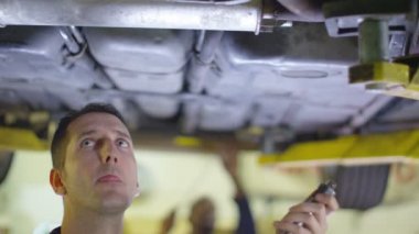 Bir araba altında çalışan makinist
