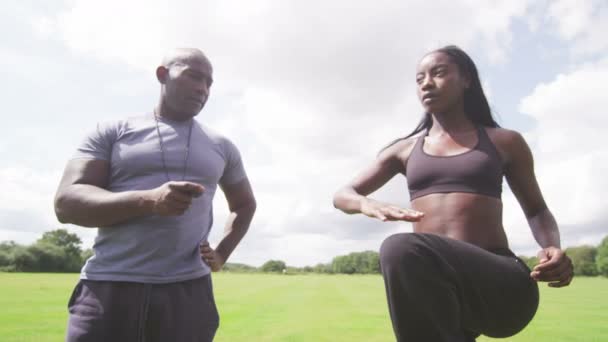 Woman stretching out with trainer — Stock Video