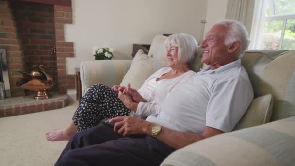 Seniorenpaar schaut zu Hause fern — Stockvideo