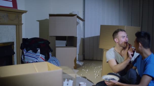 Gay casal sentado entre caixas no casa — Vídeo de Stock