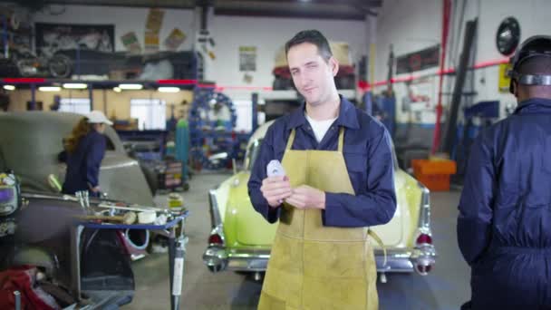 Mecánico sonriente en taller de garaje — Vídeo de stock