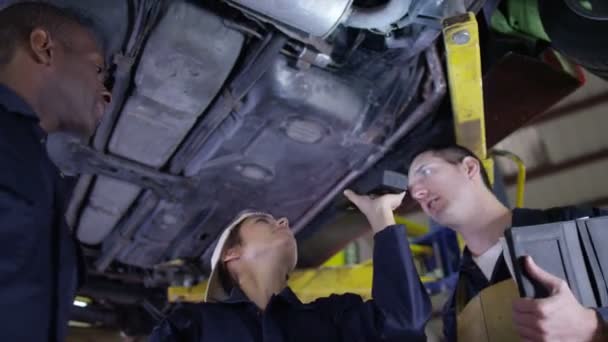 Mecânica trabalhando debaixo de um carro — Vídeo de Stock