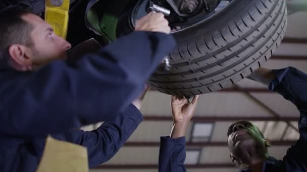 Mechaników pracujących pod spodem samochodu — Wideo stockowe