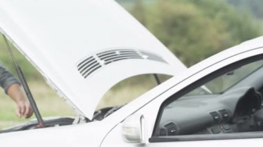 adam arabasını tamir dener