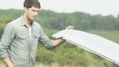 adam kırık araba ile kaput altında görünüyor