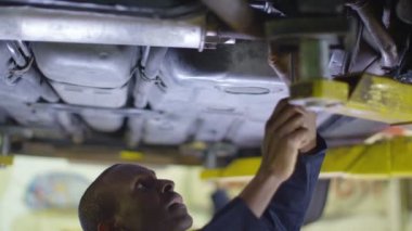 Bir araba altında çalışan makinist