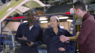 Müşteriye çalışmaları hakkında konuşurken araba mekaniği