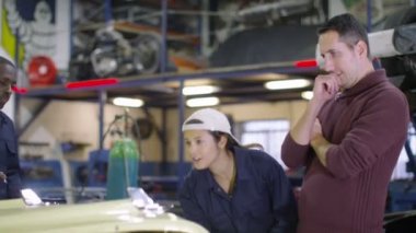 Müşteriye çalışmaları hakkında konuşurken araba mekaniği