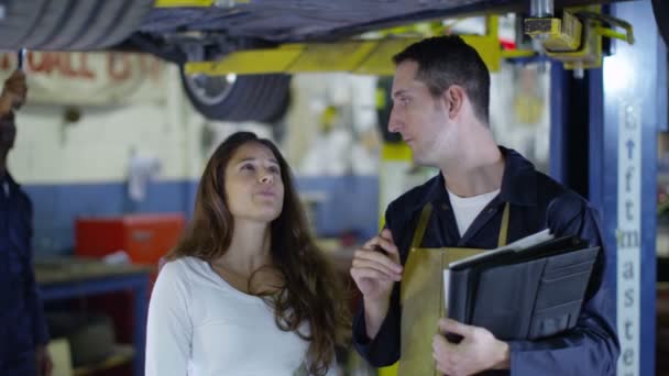 Механик говорит с клиентом о машине — стоковое видео