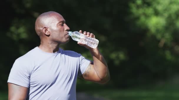 Uomo atletico che beve una bottiglia d'acqua — Video Stock