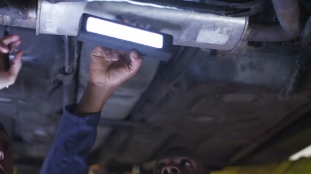 Mecánicos trabajando debajo de un coche — Vídeos de Stock