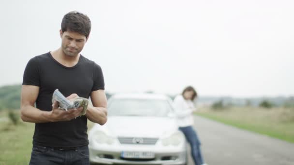 Mann mit kaputtem Auto am Straßenrand — Stockvideo