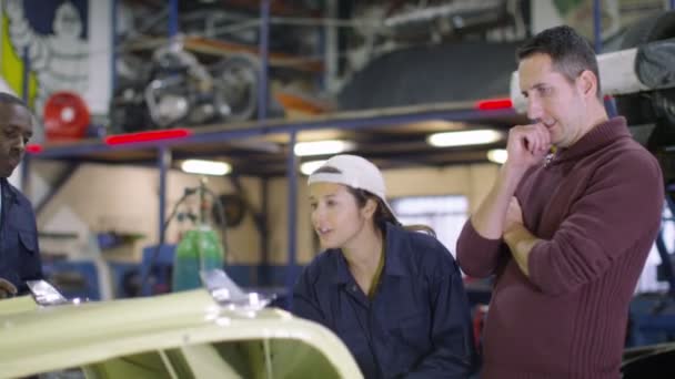 Mechaniker sprechen mit Kunden über Arbeit am Auto — Stockvideo